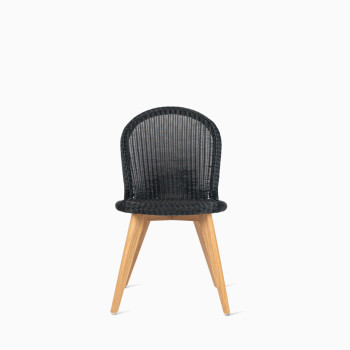 Front view of Vincent Sheppard’s Damien chair with a black seat and teak base, shown in a studio setting.