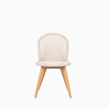 Front view of Vincent Sheppard’s Damien chair with an Old Lace-coloured seat and teak base, shown in a studio setting.