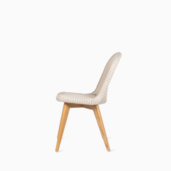 Side view of Vincent Sheppard’s Damien chair with an Old Lace-coloured seat and teak base, displayed in a studio setting.