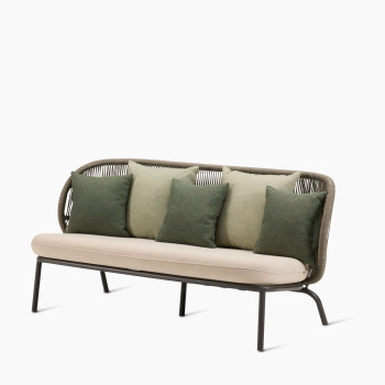 Kodo Loungesofa in Fossil Grey mit Lloyd Loom-Rahmen, beigem Sitzkissen und grünen Dekokissen, elegantes Outdoor-Design.	