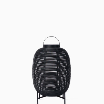 Vincent Sheppard Tika lantern with black woven frame and sturdy steel base, featuring a top handle.	