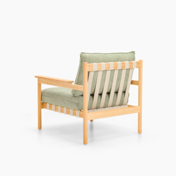 Rear view of Vincent Sheppard Oda lounge chair with Fig Green cushions and untreated teak frame in flax finish	