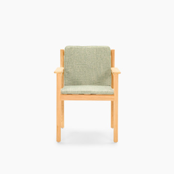 Front view of Vincent Sheppard Oda dining chair with Fig Green cushion and untreated teak frame	
